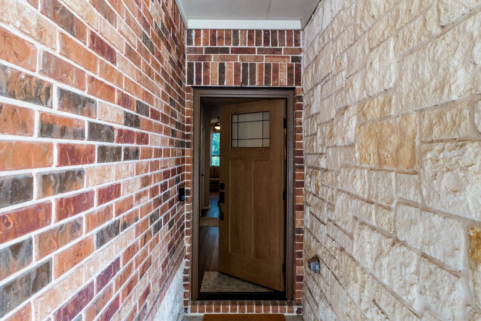 1133 Yellow Iris Road Leander, TX 78641 - Photo 36 of 37 Entryway featuring a wood-panel door with leaded glass accents, framed by multi-tone brick and rough-cut stone veneer