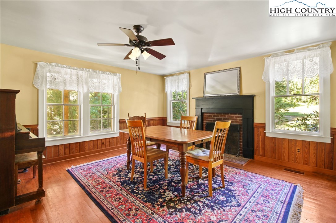 2166 George Hayes Road Boone, NC 28607 - Photo 21 of 50 a dining room with wooden floor a rug a fireplace and a window