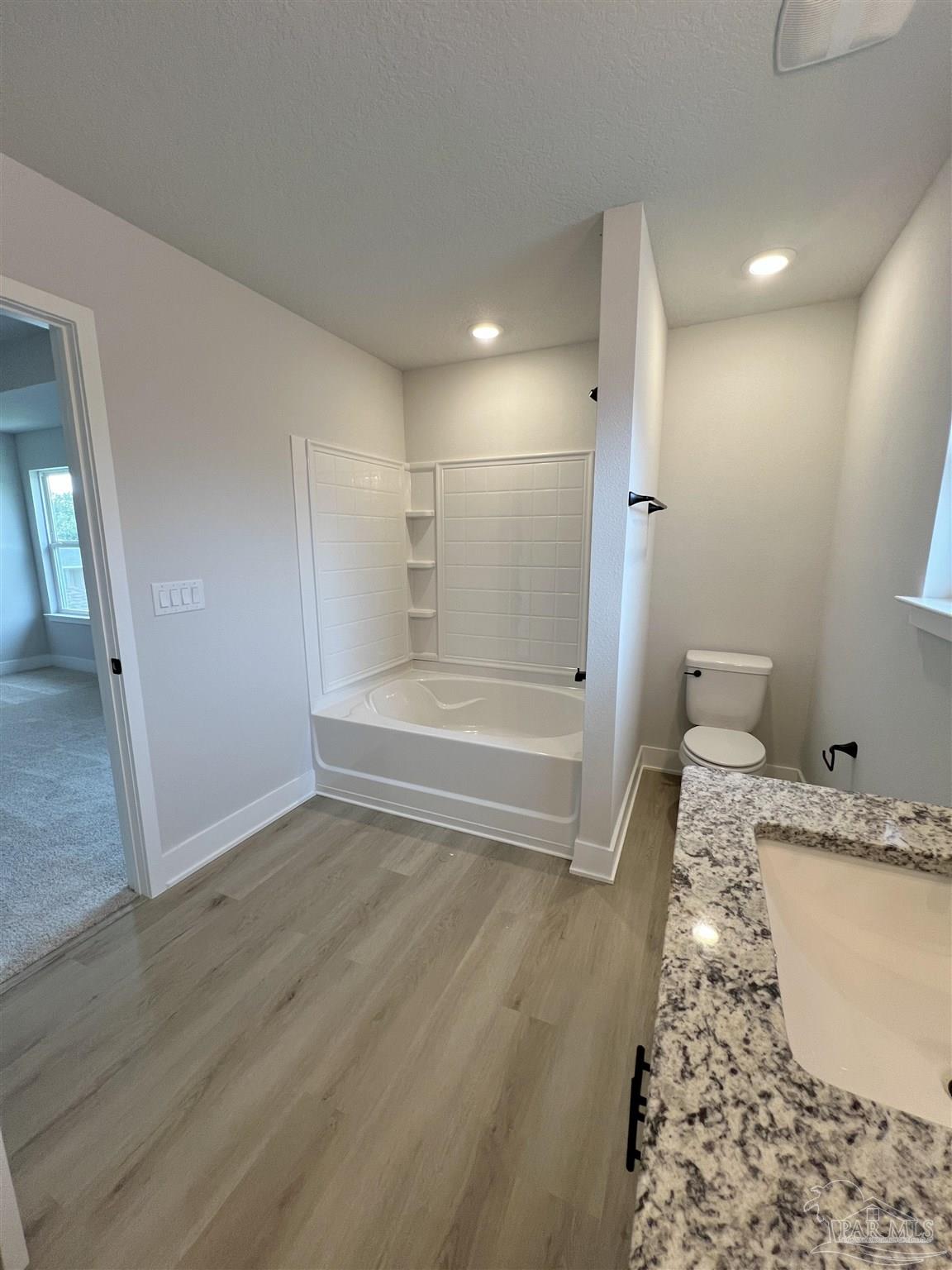 3339 Bliss Lane, Unit 9E Cantonment, FL 32533 - Photo 11 of 13 a bathroom with a granite countertop sink a toilet and shower