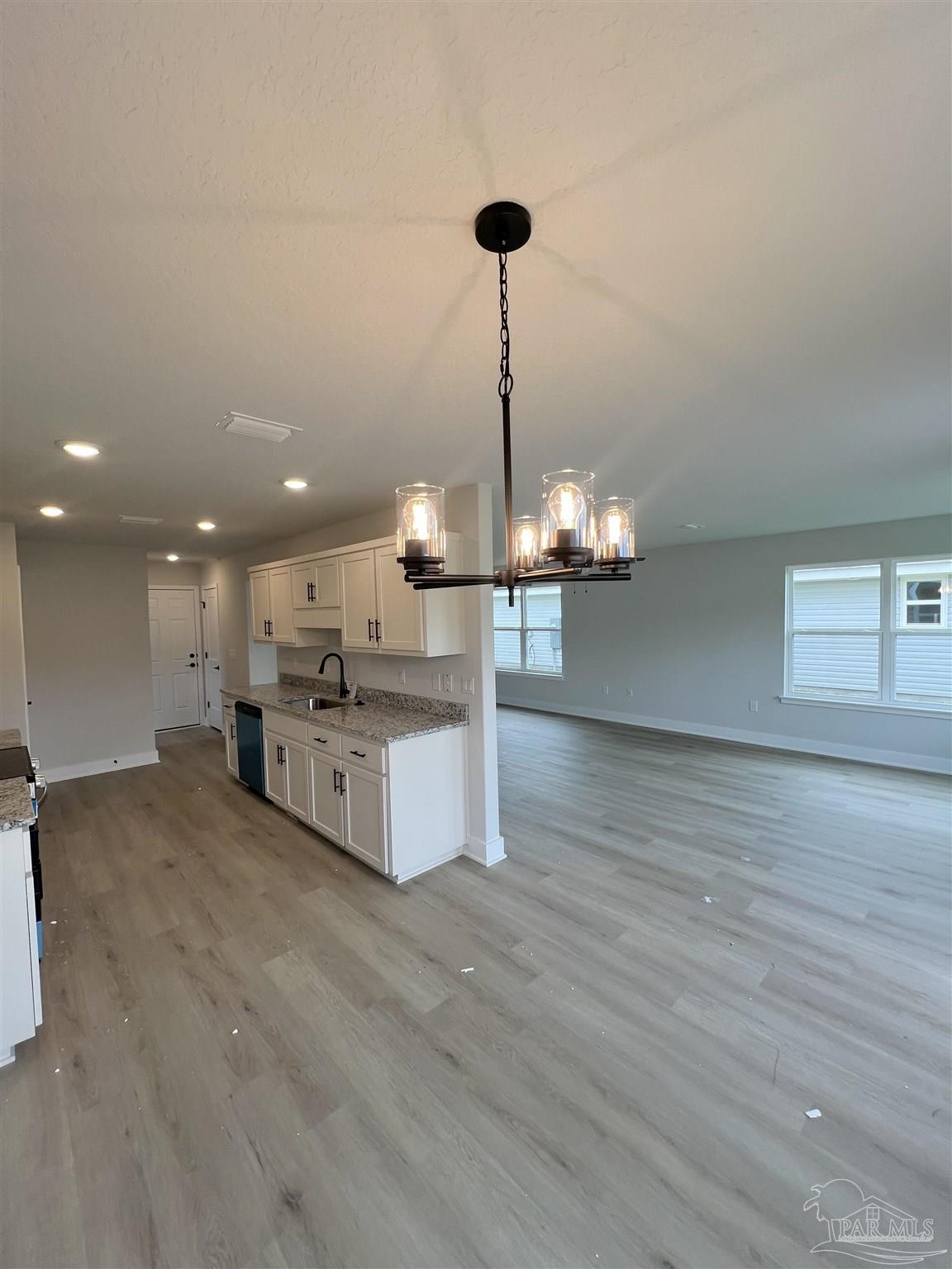 3339 Bliss Lane, Unit 9E Cantonment, FL 32533 - Photo 4 of 13 a view of a kitchen with granite countertop wooden floor stainless steel appliances and cabinets