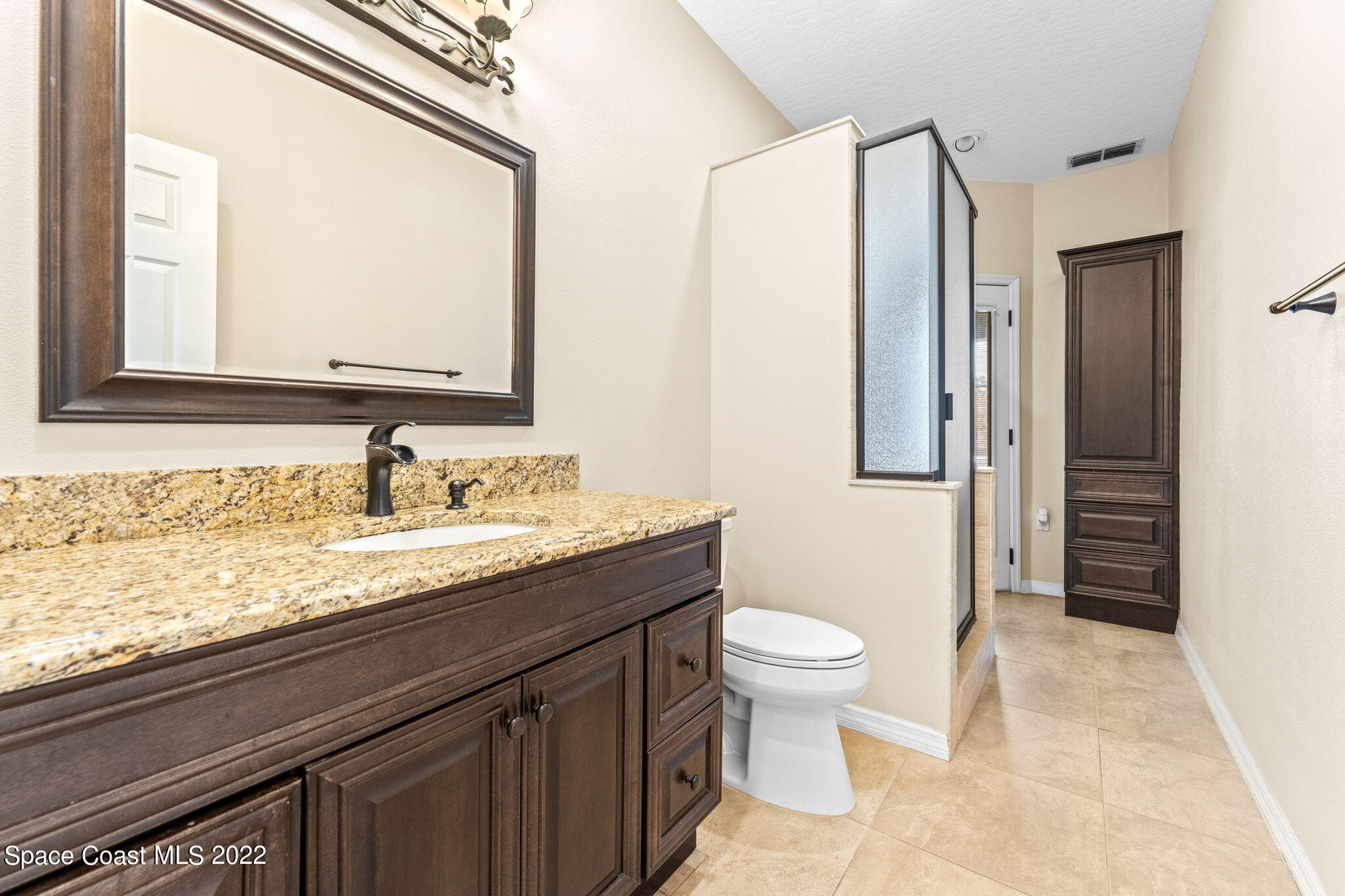 4668 Canard Road Melbourne, FL 32934 - Photo 11 of 29 a bathroom with a granite countertop sink toilet and mirror