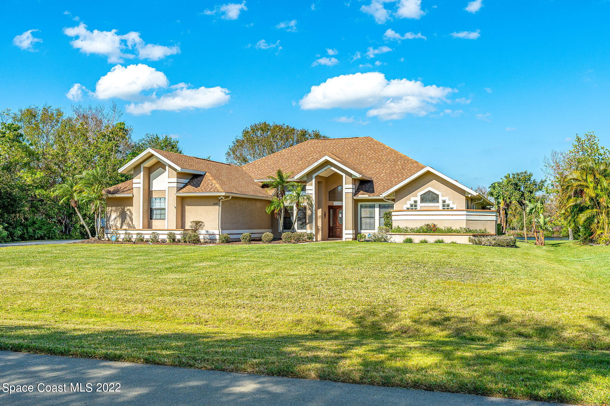 4668 Canard Road Melbourne, FL 32934 - Photo 28 of 29 a front view of a house with a garden and trees