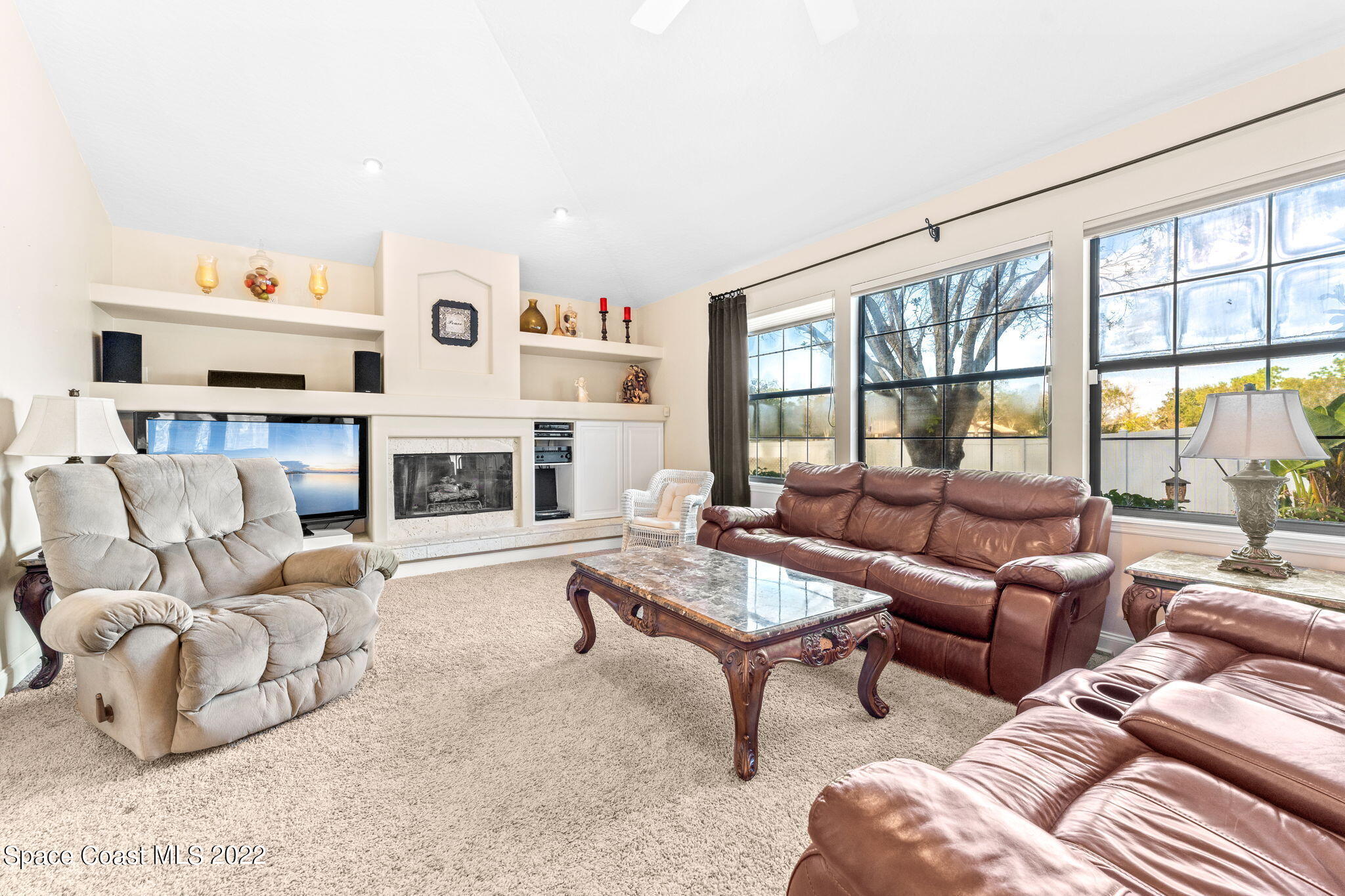 4668 Canard Road Melbourne, FL 32934 - Photo 3 of 29 a living room with furniture large window and a fireplace