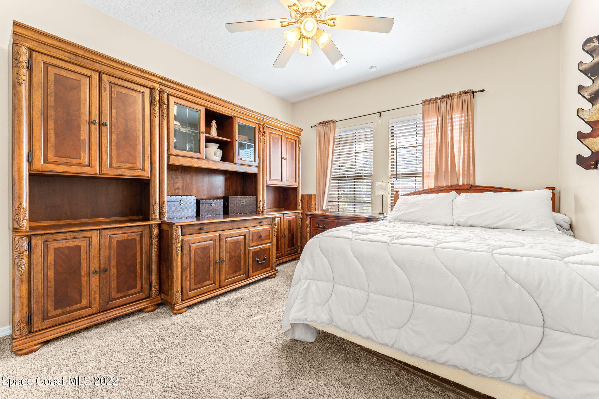 4668 Canard Road Melbourne, FL 32934 - Photo 10 of 29 a bedroom with a large bed and cabinets