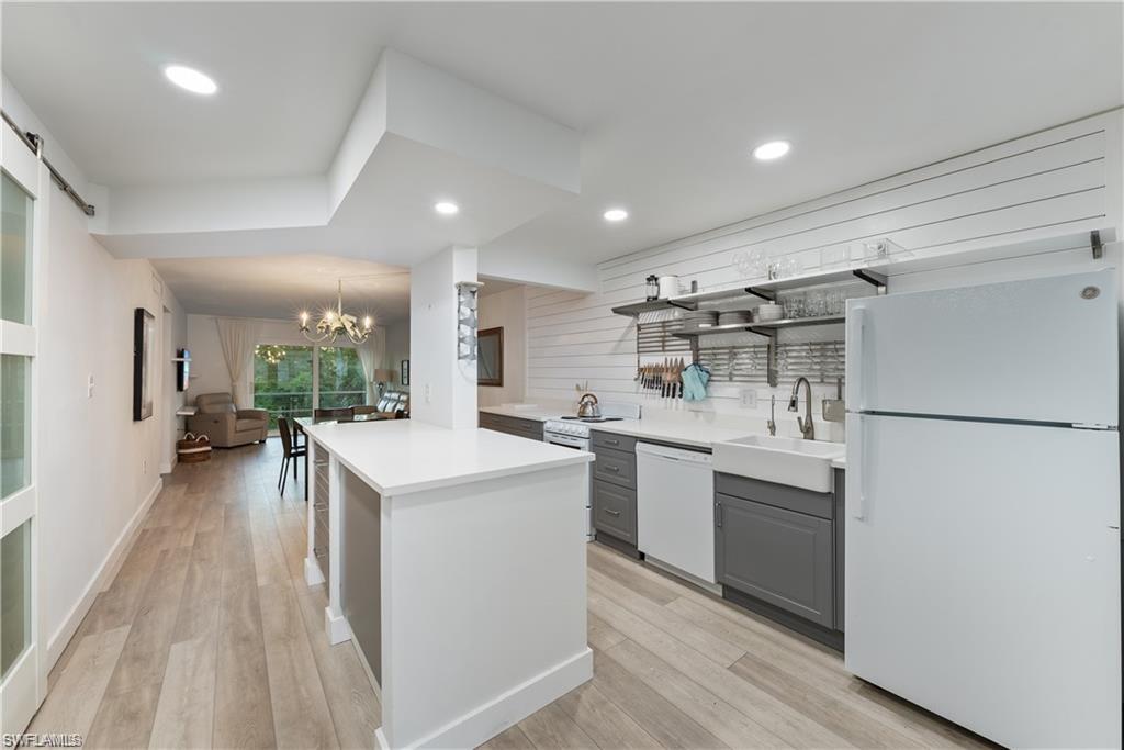 a kitchen with a sink a refrigerator and chairs