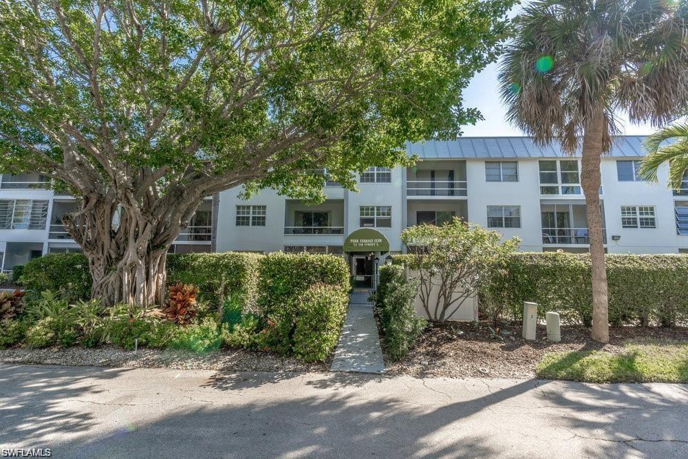 72 7th Street South, Unit 310 Naples, FL 34102 - Photo 20 of 20 a front view of a house with a yard and potted plants