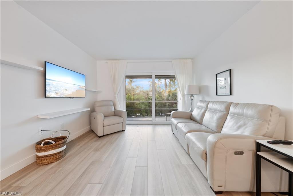 72 7th Street South, Unit 310 Naples, FL 34102 - Photo 8 of 20 a living room with furniture and a wooden floor