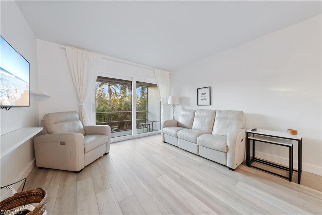 72 7th Street South, Unit 310 Naples, FL 34102 - Photo 9 of 20 a living room with furniture and a large window