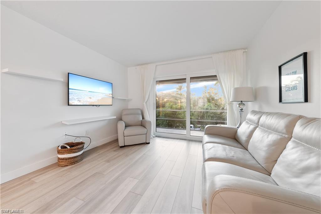 72 7th Street South, Unit 310 Naples, FL 34102 - Photo 10 of 20 a living room with furniture and a large window