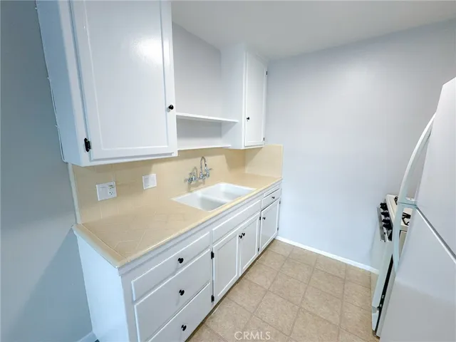 a room with white cabinets and sink