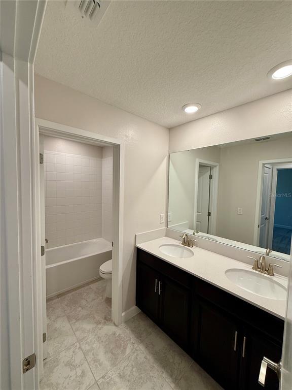 1421 Happy Bird Lane Winter Springs, FL 32708 - Photo 14 of 16 a bathroom with a double vanity sink toilet mirror and bathtub