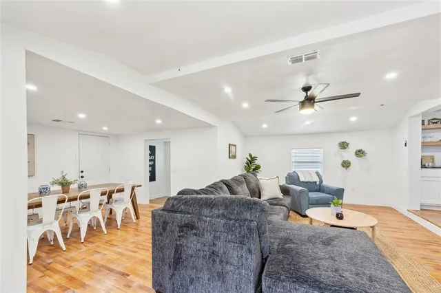 a living room with furniture kitchen view and a chandelier