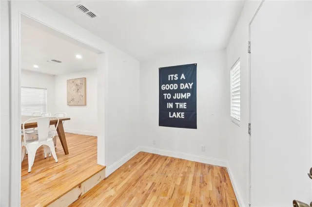 a view of a bedroom with wooden floor and a bathroom