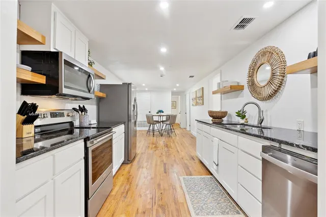a kitchen with stainless steel appliances granite countertop a refrigerator sink and stove