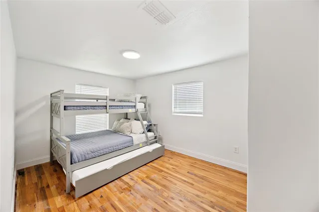 a bedroom with a bed and wooden floor