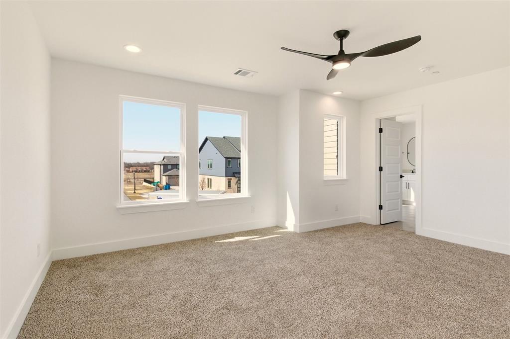 8902 Lowell Street Rowlett, TX 75089 - Photo 21 of 32 an empty room with windows and ceiling fan