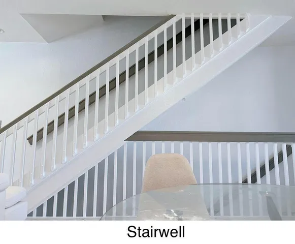 a view of staircase with railing and white walls