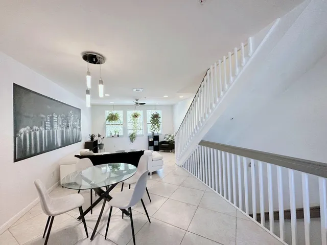 a dining room with furniture and a chandelier fan