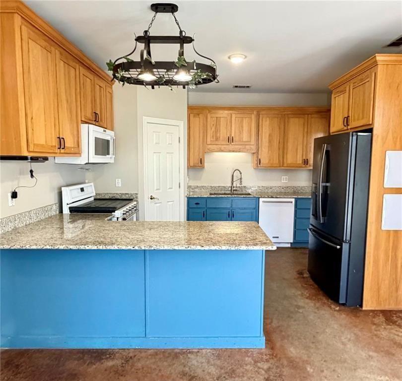 9011 High Point Road Villa Rica, GA 30180 - Photo 22 of 68 a kitchen with granite countertop a refrigerator a stove a sink dishwasher and wooden cabinets