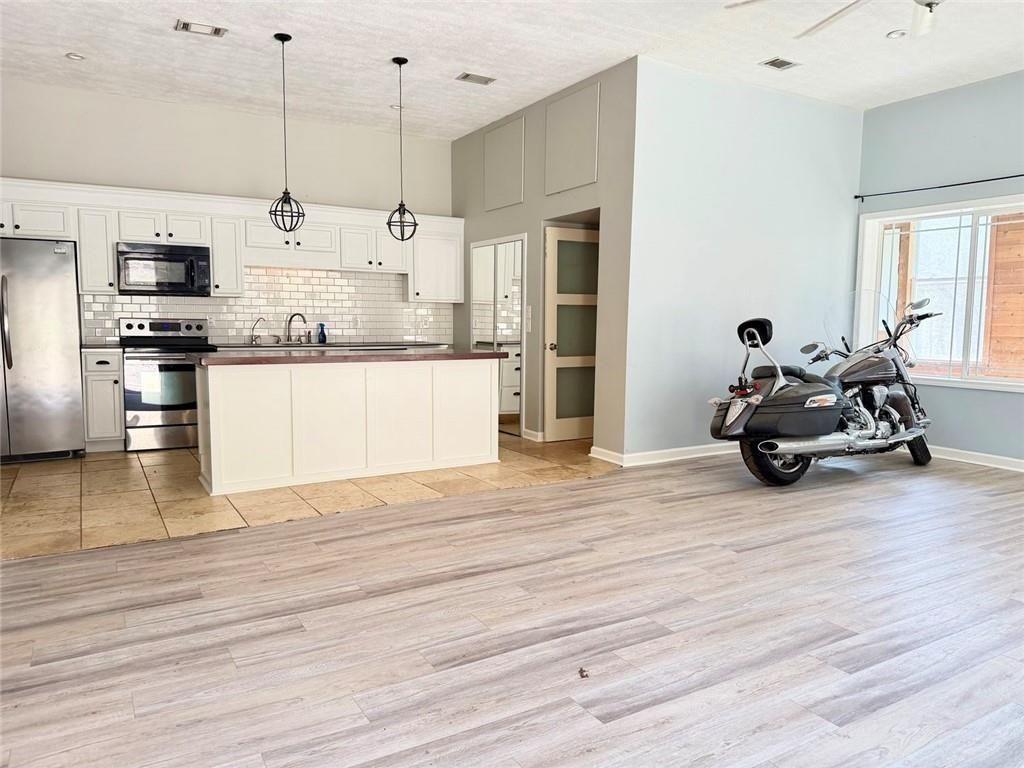 9011 High Point Road Villa Rica, GA 30180 - Photo 42 of 68 a kitchen with stainless steel appliances kitchen island granite countertop a stove a refrigerator and a wooden floors