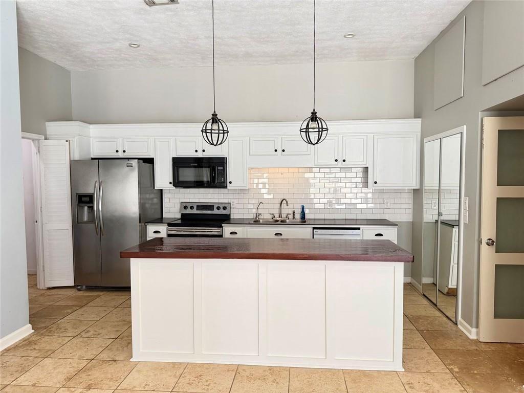 9011 High Point Road Villa Rica, GA 30180 - Photo 44 of 68 a kitchen with kitchen island a counter top a stove a refrigerator and a cabinets