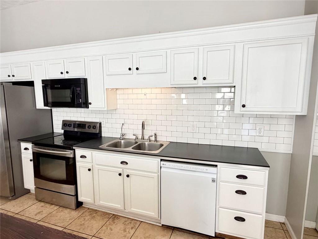9011 High Point Road Villa Rica, GA 30180 - Photo 45 of 68 a kitchen with granite countertop a sink a stove and cabinets