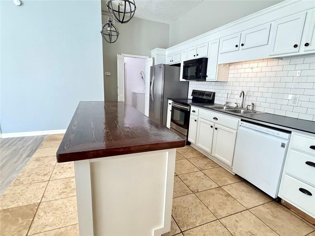 9011 High Point Road Villa Rica, GA 30180 - Photo 47 of 68 a kitchen with stainless steel appliances a sink a stove top oven a granite counter tops and white cabinets