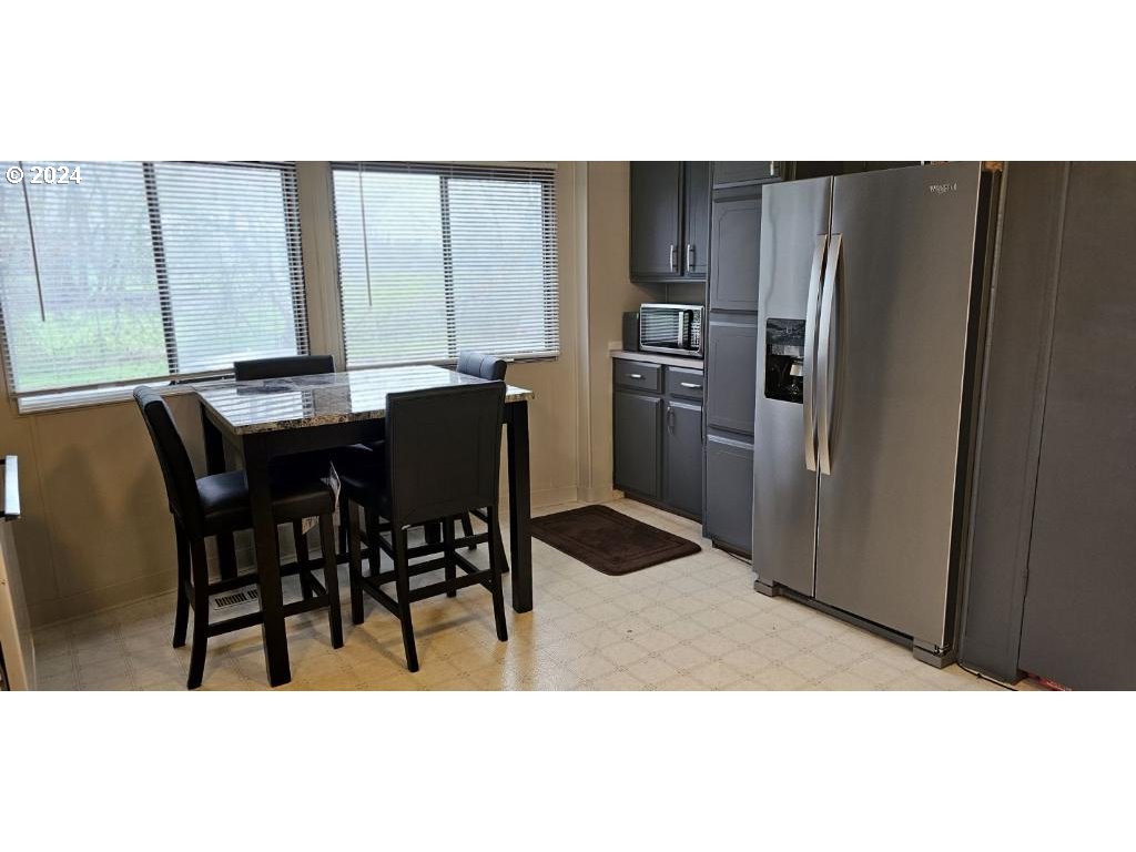 86072 Gossler Road Eugene, OR 97405 - Photo 4 of 19 a kitchen with stainless steel appliances kitchen island granite countertop a refrigerator a stove a kitchen island with a dining table and chair