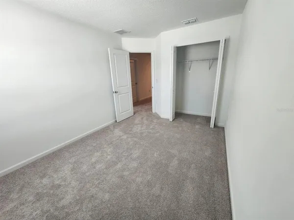 a view of an empty room and closet area