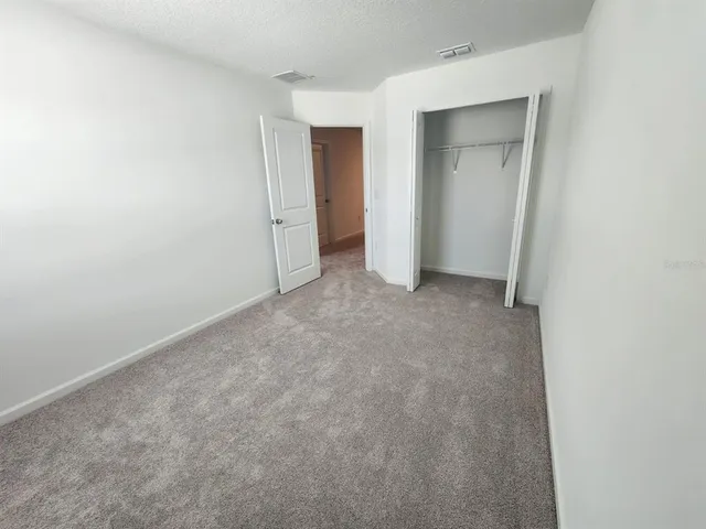 a view of an empty room and closet area
