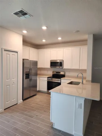 a kitchen with refrigerator cabinets and wooden floor