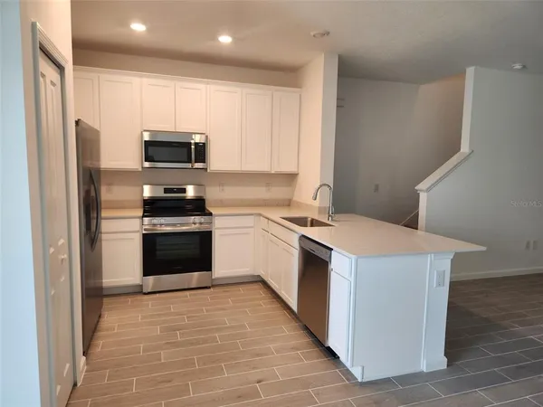 a kitchen with a stove a sink and a refrigerator