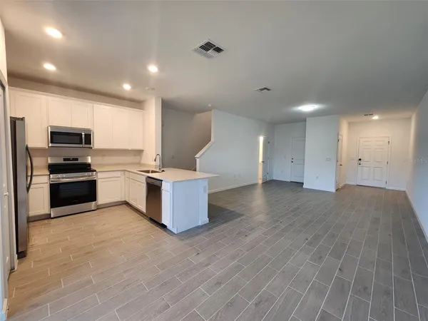 a kitchen with stainless steel appliances kitchen island granite countertop a stove and a refrigerator