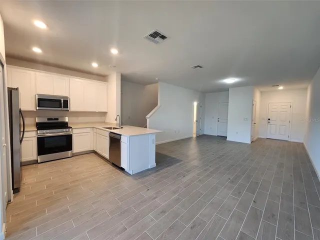 a kitchen with stainless steel appliances kitchen island granite countertop a stove and a refrigerator