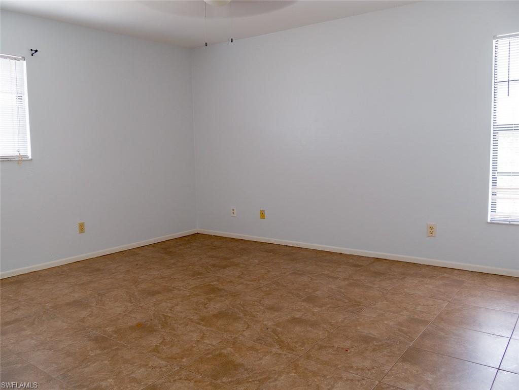 19029-19031 Holly Road Fort Myers, FL 33967 - Photo 13 of 15 Spare room with baseboards and a ceiling fan