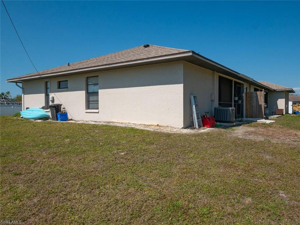 19029-19031 Holly Road Fort Myers, FL 33967 - Photo 4 of 15 View of side of property with a yard, stucco siding, and roof with shingles