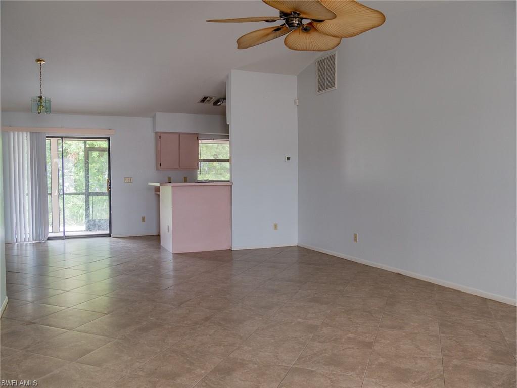 19029-19031 Holly Road Fort Myers, FL 33967 - Photo 7 of 15 Unfurnished living room with a ceiling fan and baseboards