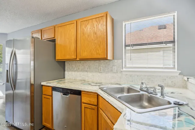 a kitchen with stainless steel appliances granite countertop a sink and a window