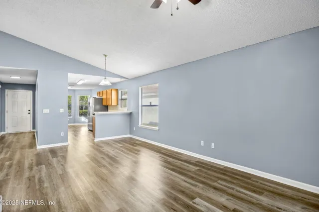 a view of a kitchen with wooden floor and a window
