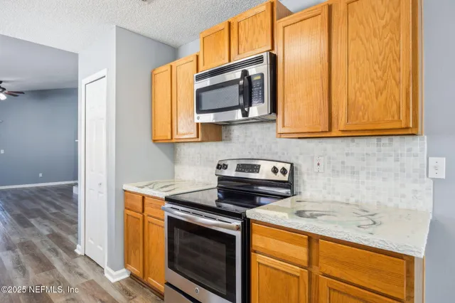 a kitchen with stainless steel appliances granite countertop a stove microwave and sink