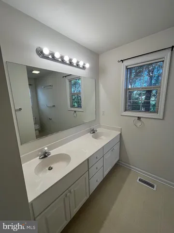 a bathroom with a double vanity sink and a mirror