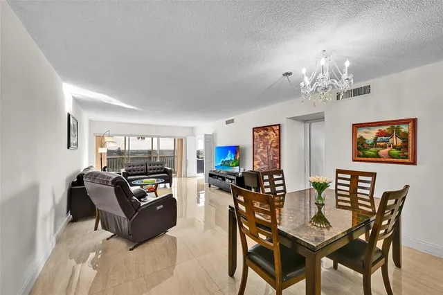 a view of a dining room with furniture a chandelier and wooden floor