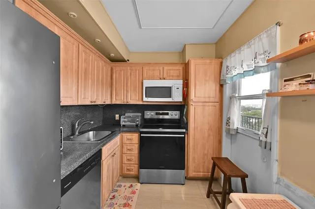 a kitchen with stainless steel appliances granite countertop a refrigerator and a stove top oven