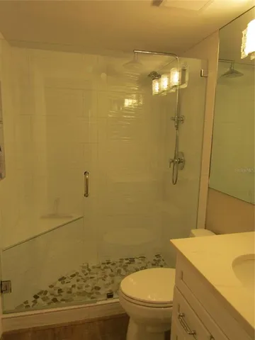a bathroom with a granite countertop toilet and a sink
