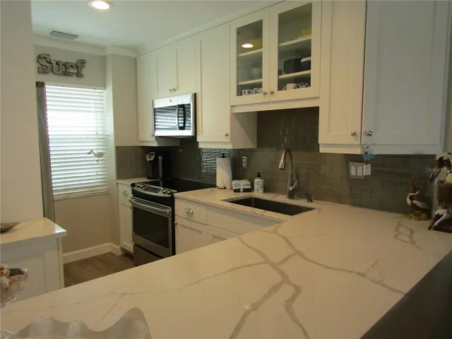 a kitchen with a stove a sink and a microwave