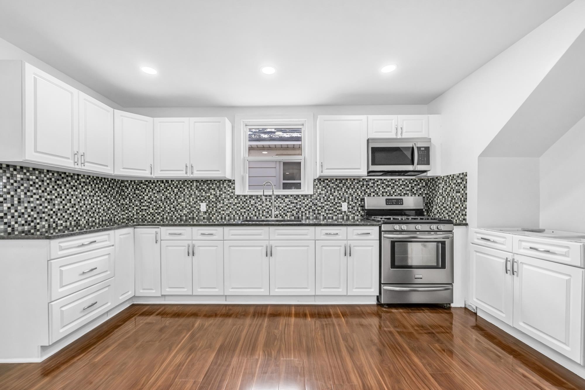 a kitchen with granite countertop white cabinets and white appliances