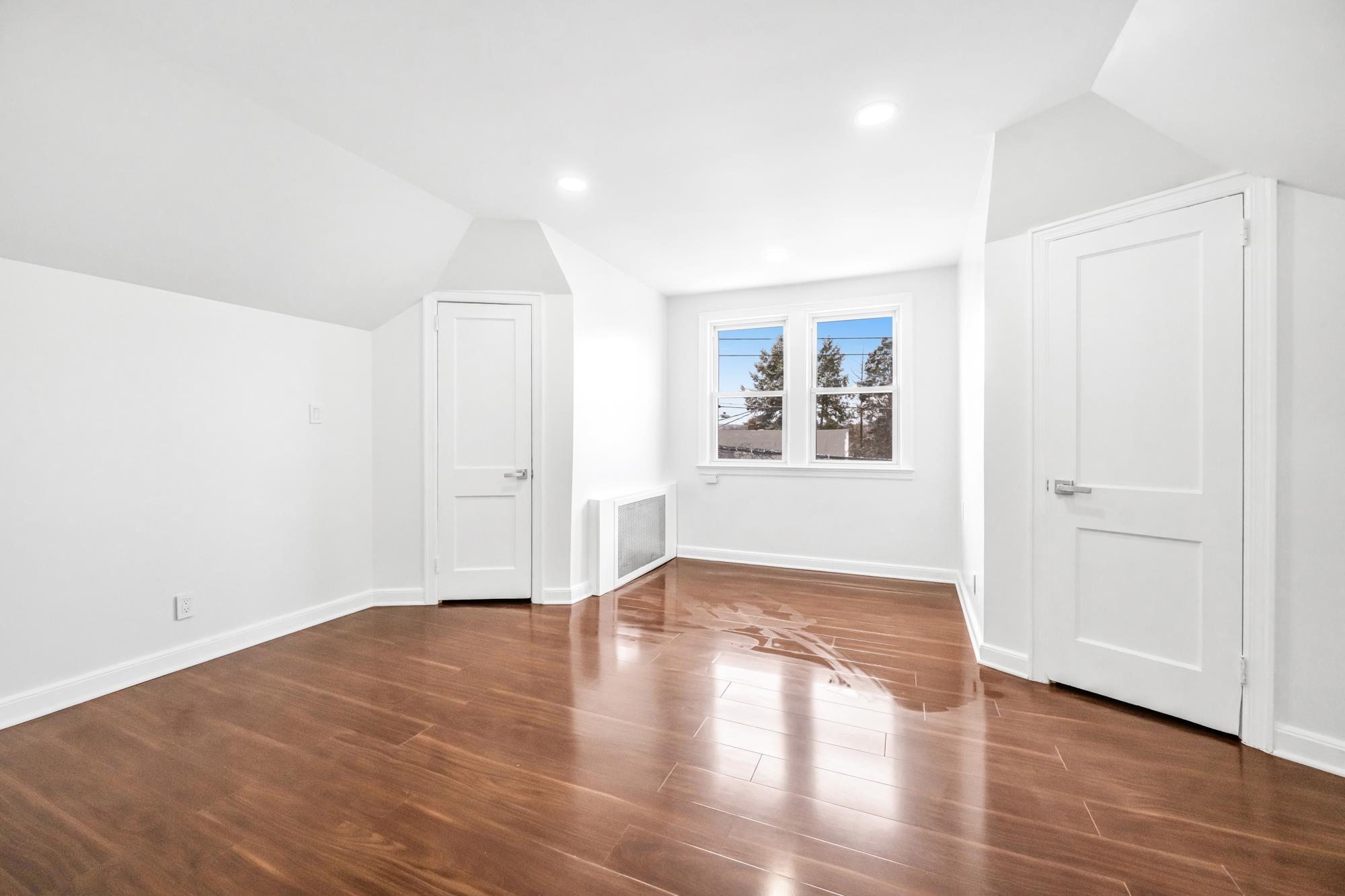 284 MacArthur Avenue, Unit 2 Garfield, NJ 07026 - Photo 12 of 19 an empty room with wooden floor and windows