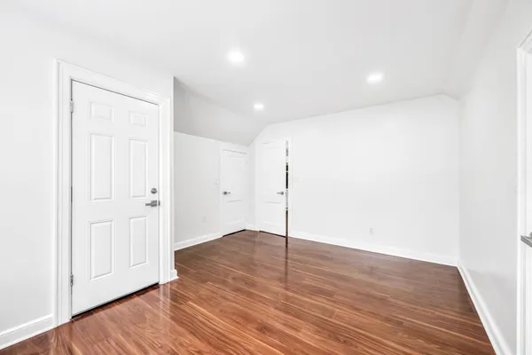 a view of an empty room with wooden floor