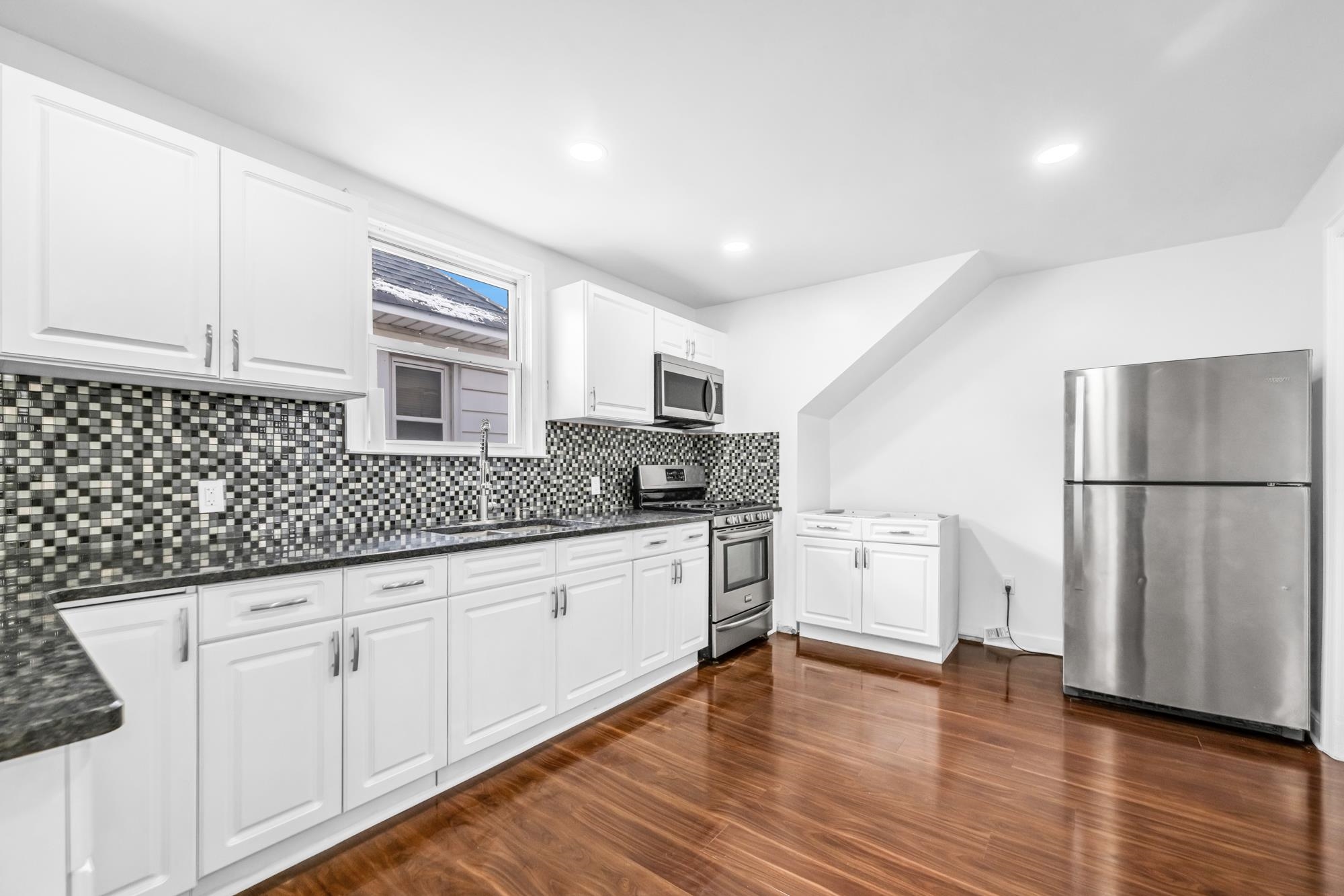284 MacArthur Avenue, Unit 2 Garfield, NJ 07026 - Photo 2 of 19 a kitchen with granite countertop white cabinets and white appliances