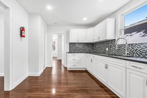 a kitchen with white cabinets and sink